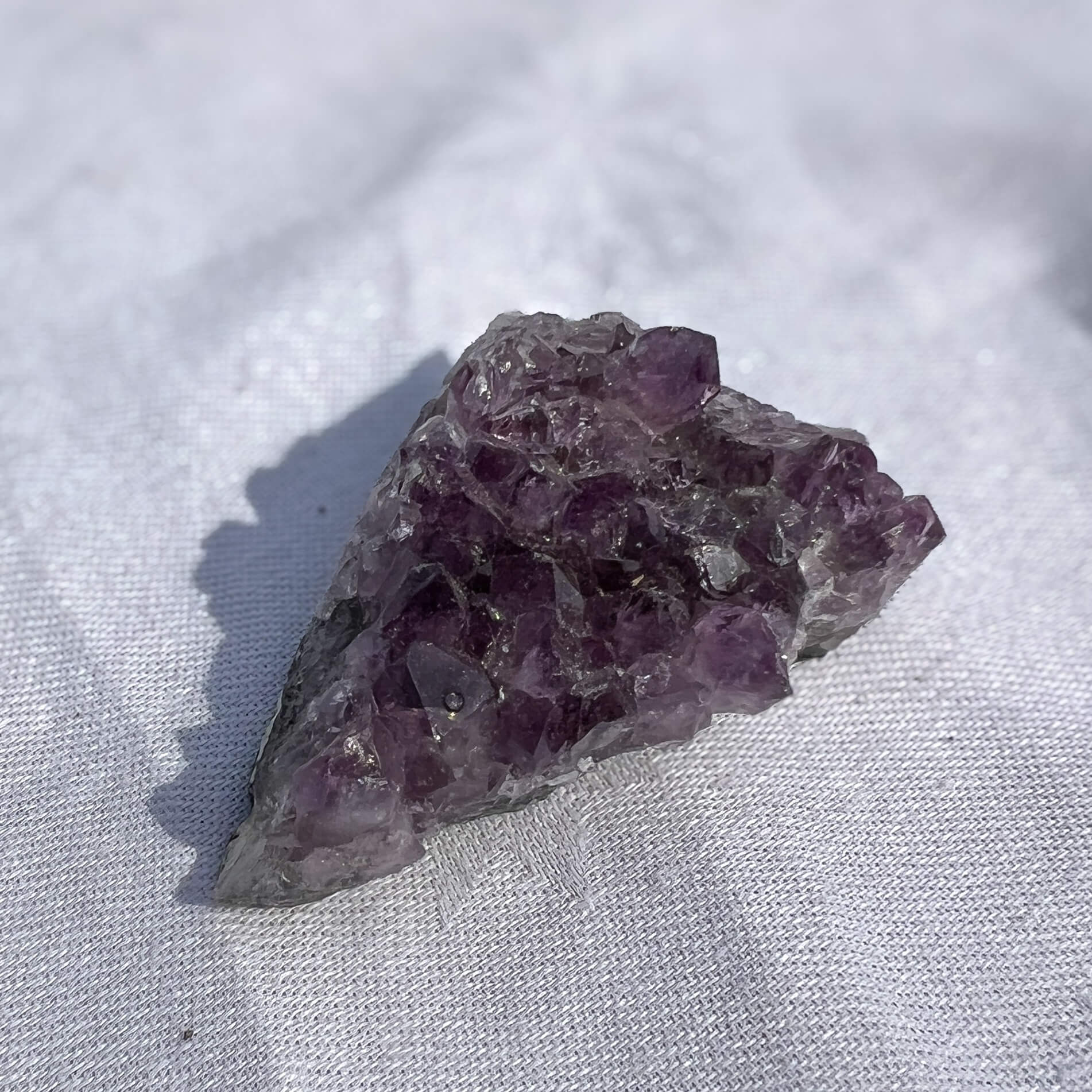 Amethyst crystal on a light fabric background