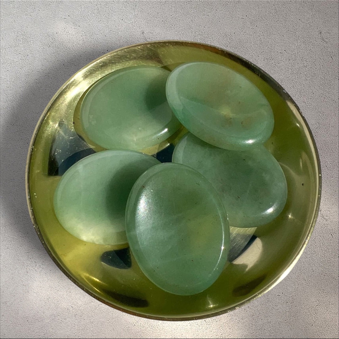 Rock + Realm Crystals green aventurine worry stones in a brass dish, smooth polished oval shape with thumb dip.