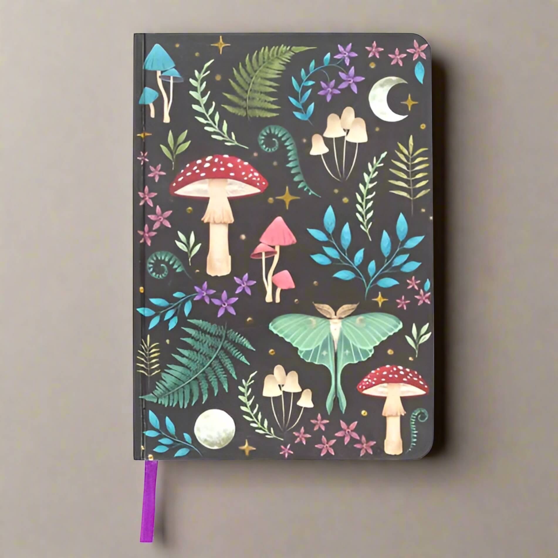 Rock + Realm Crystals Dark Forest A5 journal with whimsical mushroom, luna moth, fern, and moon illustrations on a dark background.