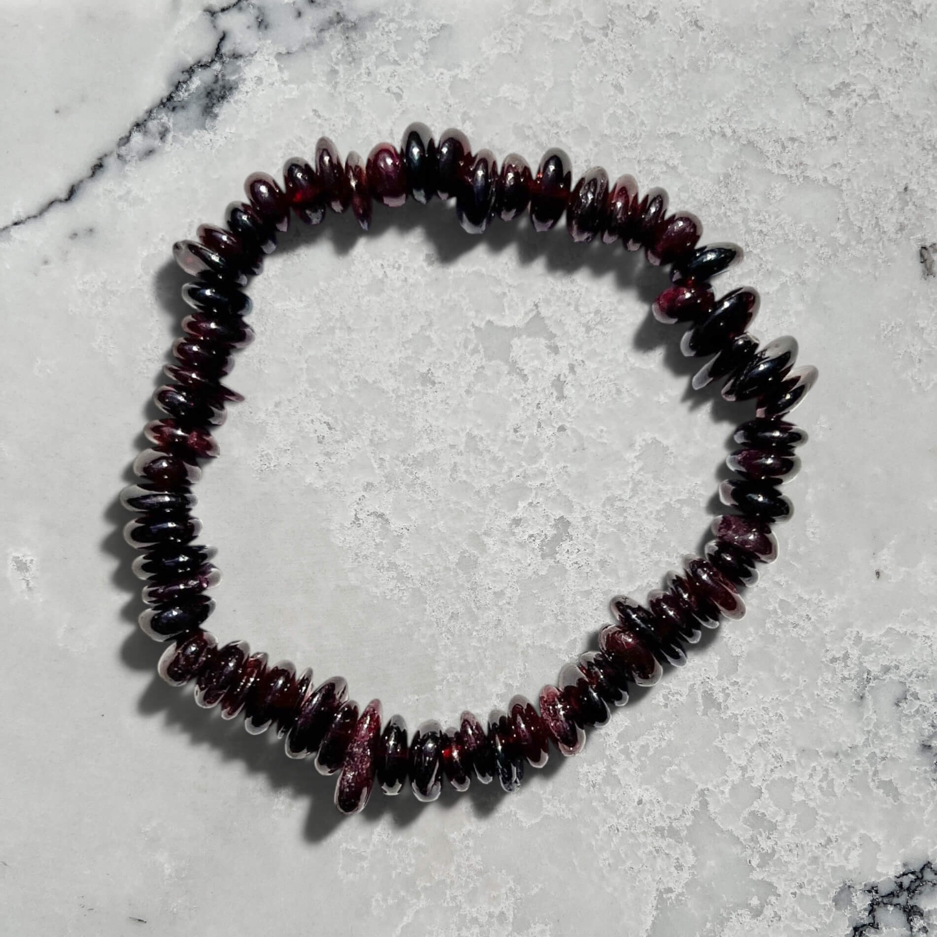 Garnet beaded bracelet on a marble surface