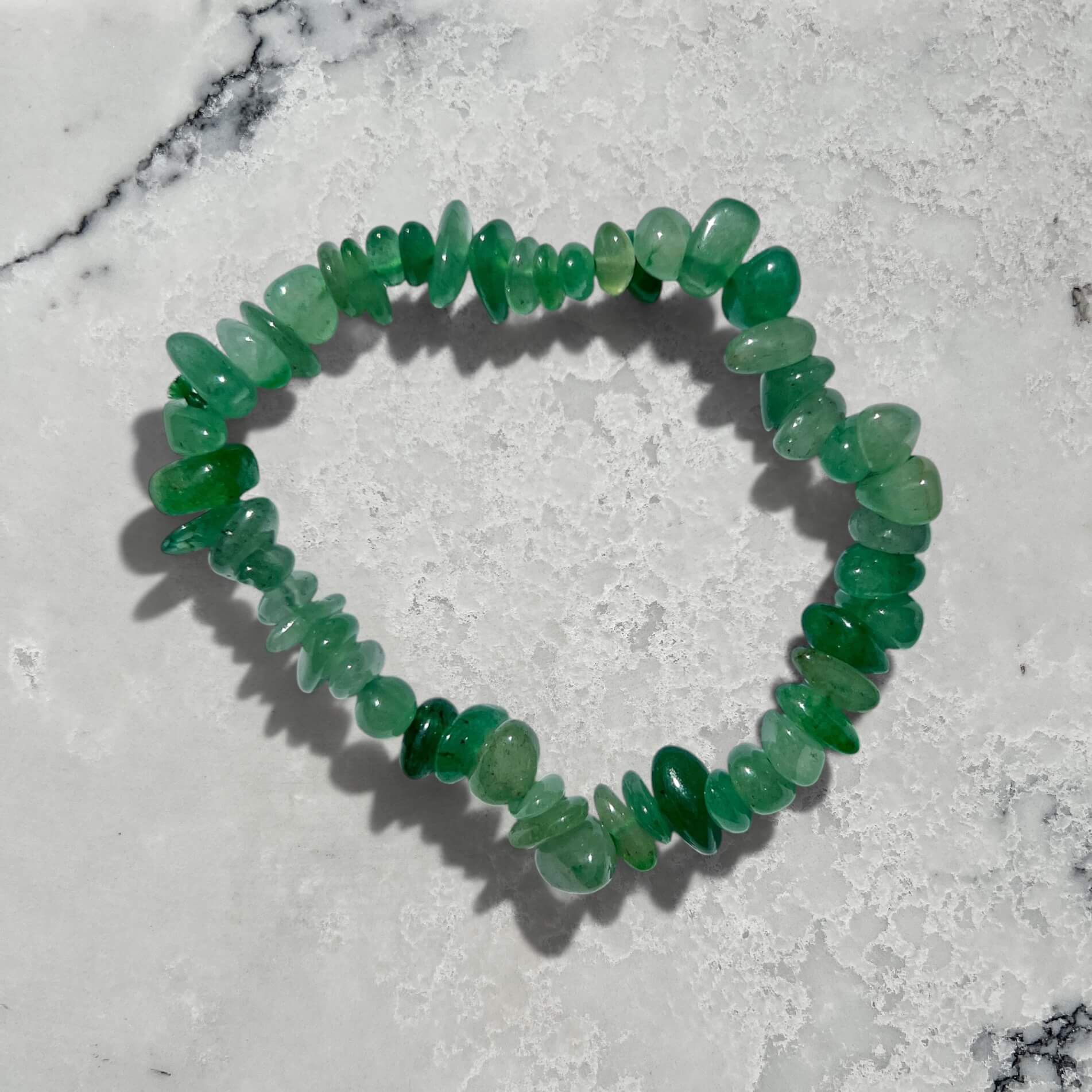 Green Aventurine crystal chip bracelet on a marble surface