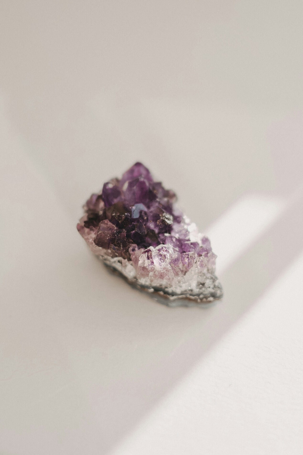 Amethyst crystal cluster on a light background