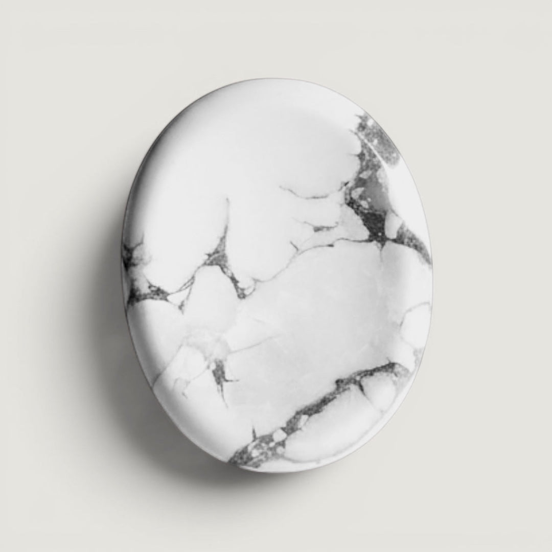 Rock + Realm Crystals polished white and grey marbled oval Howlite crystal worry stone with thumb indentation.