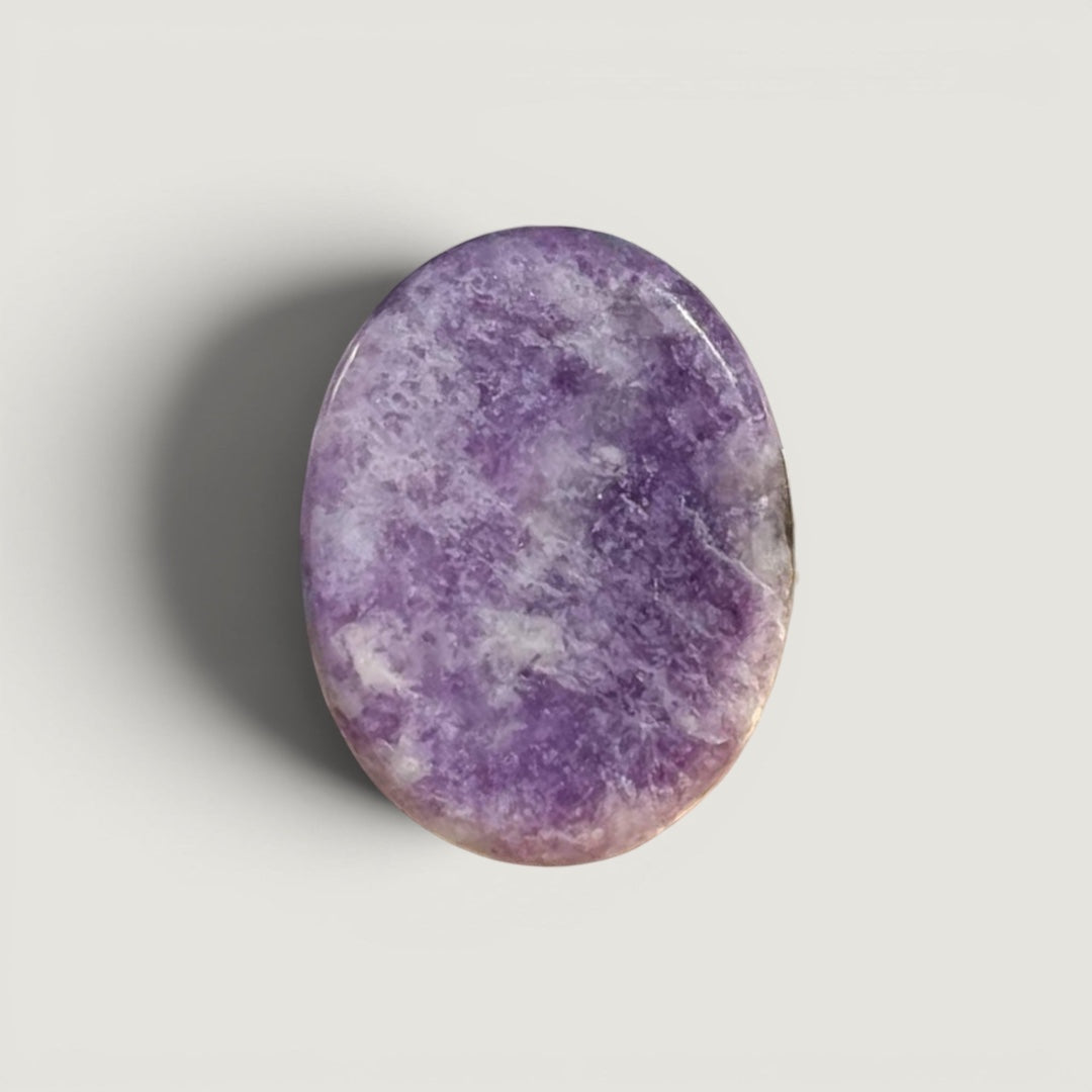 Rock + Realm Crystals Lepidolite worry stone, smooth purple with white marbling, oval shape with thumb indentation.