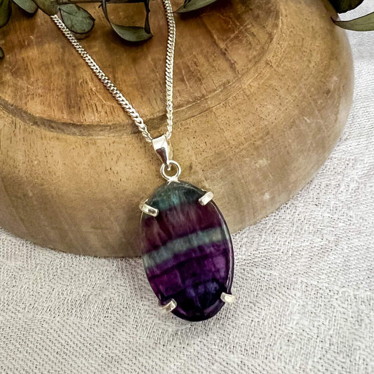 Dark purple and bright blue fluorite crystal oval pendant on a silver chain