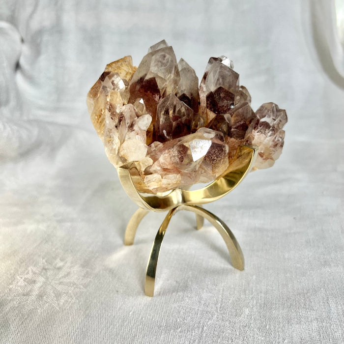 An extra large brass claw stand with a crystal cluster held between the prongs