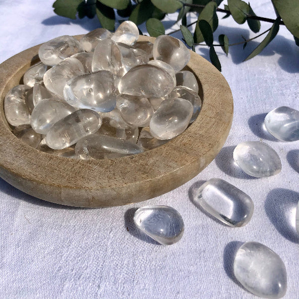 Wooden dish full of clear quartz crystal stones