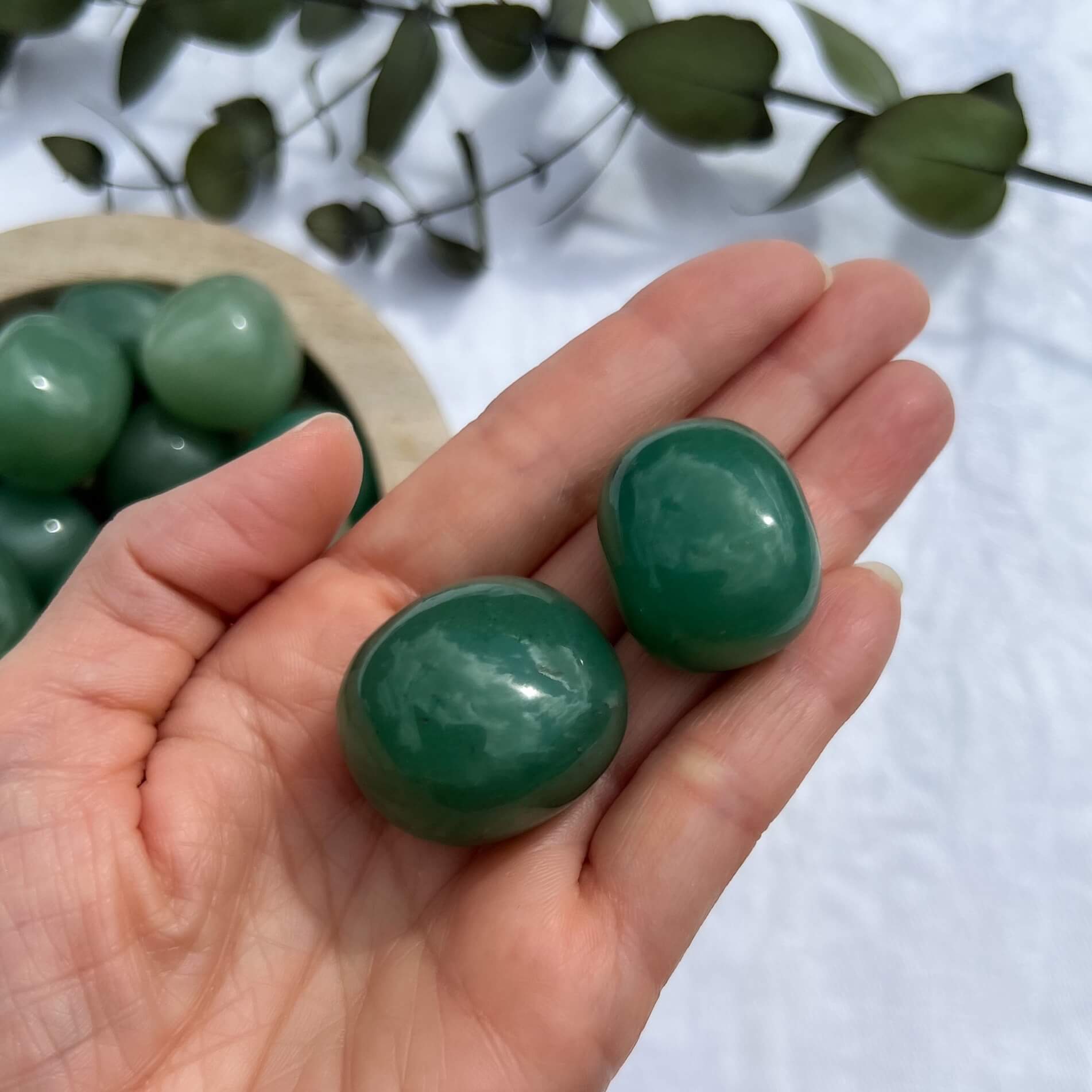 Juicy green aventurine crystal pebbles in an open hand