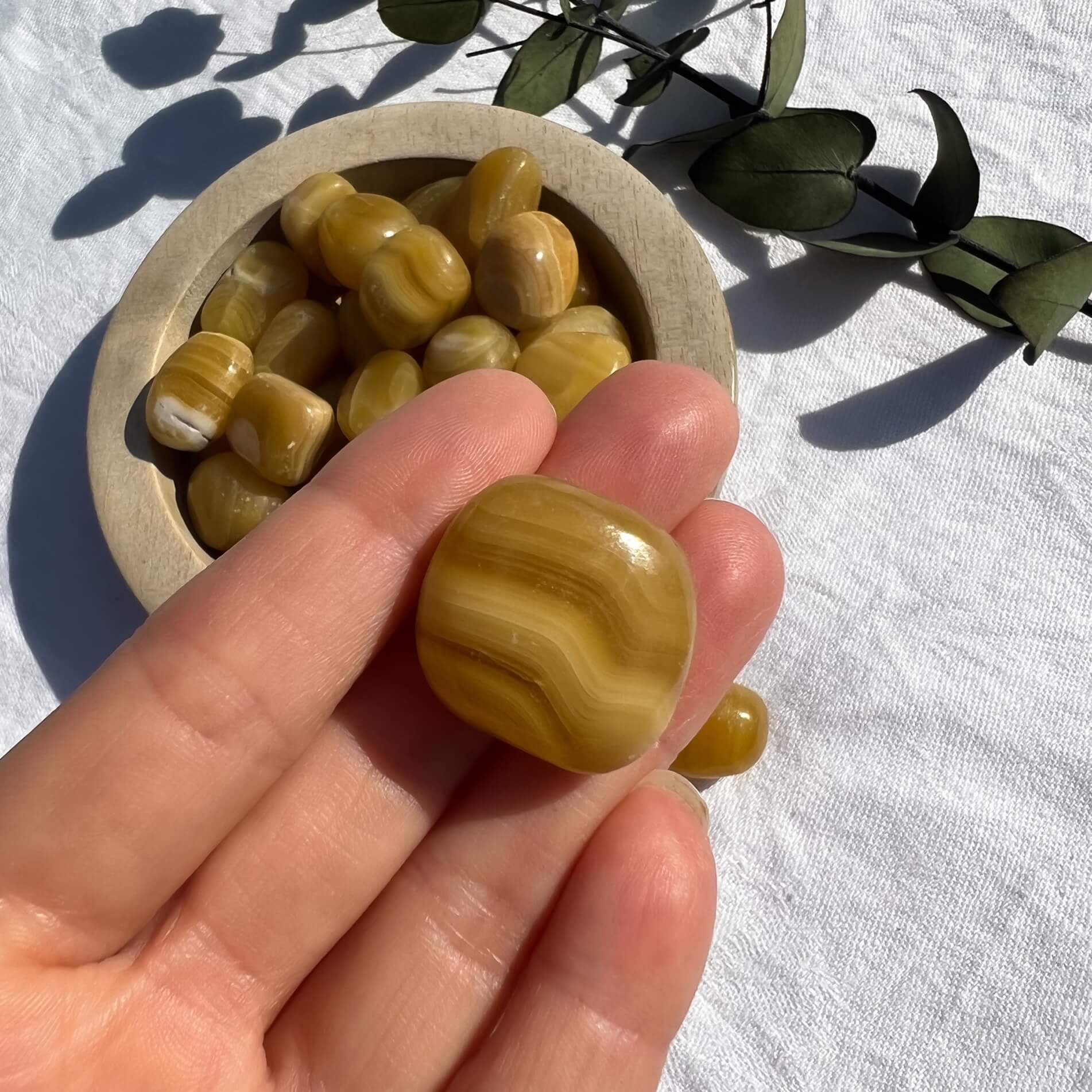 Glossy striped orange and honey coloured Orange Calcite crystal tumble stone