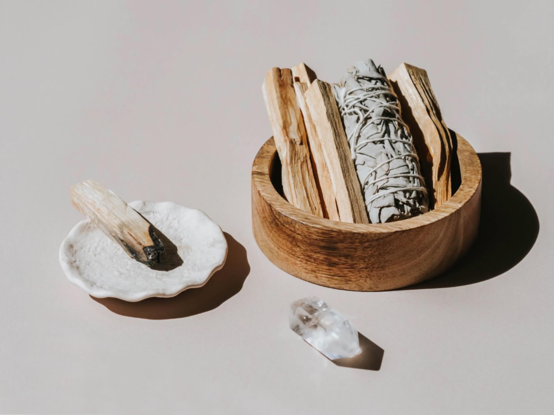Energy cleaning tools; palo santo wood, sage bundles and clear quartz crystals