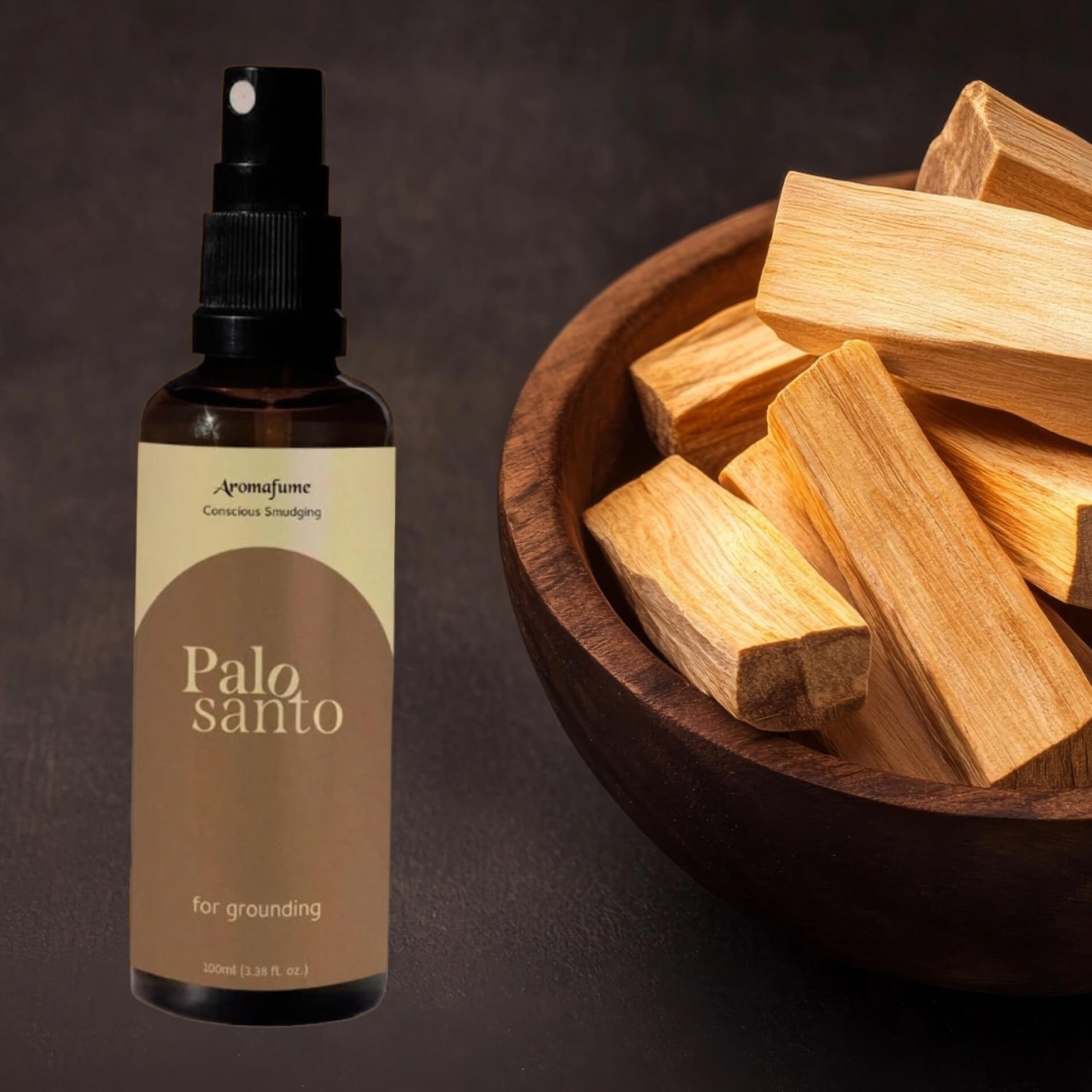 Aromatherapy bottle labeled 'Palo Santo' with palo Santo wood sticks in a bowl on a dark background