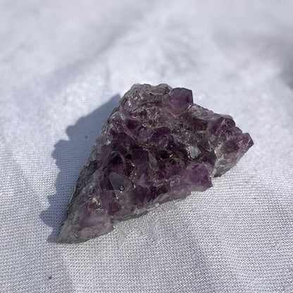 Amethyst crystal on a light fabric background
