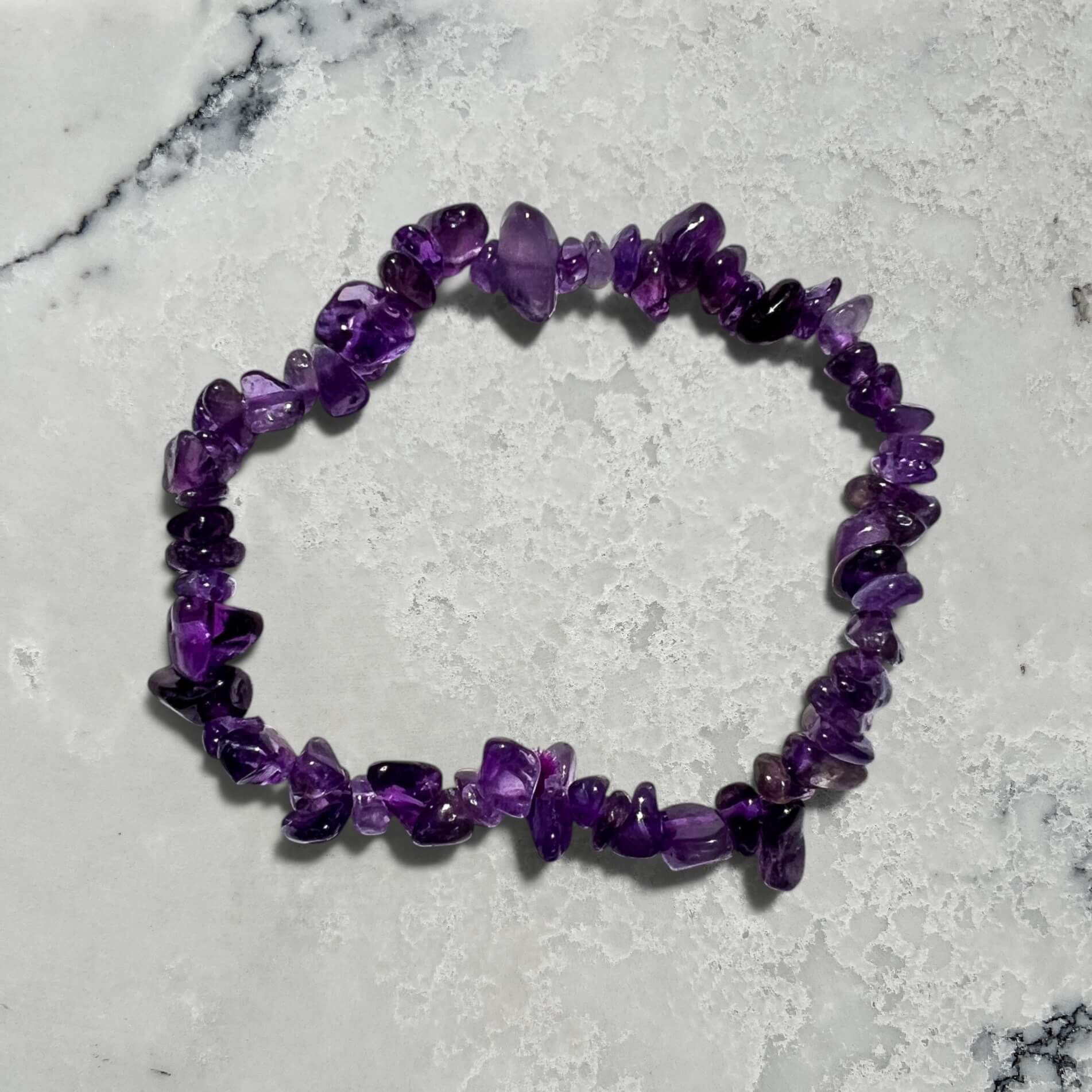 Purple amethyst crystal chip bracelet on a marble surface