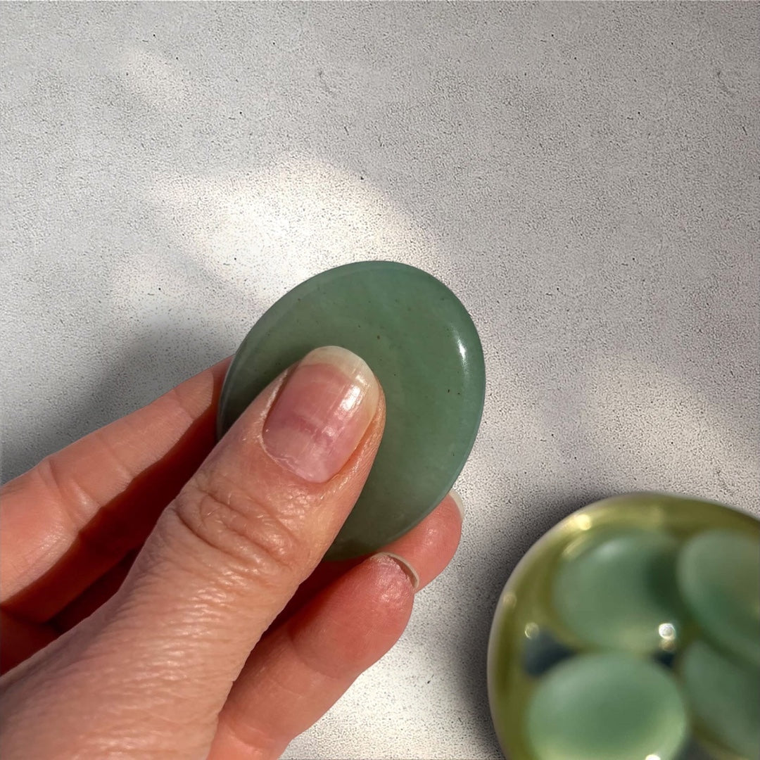 Rock + Realm Crystals green aventurine worry stone, smooth polished gemstone with thumb dip for grounding and anxiety relief held between thumb and forefinger