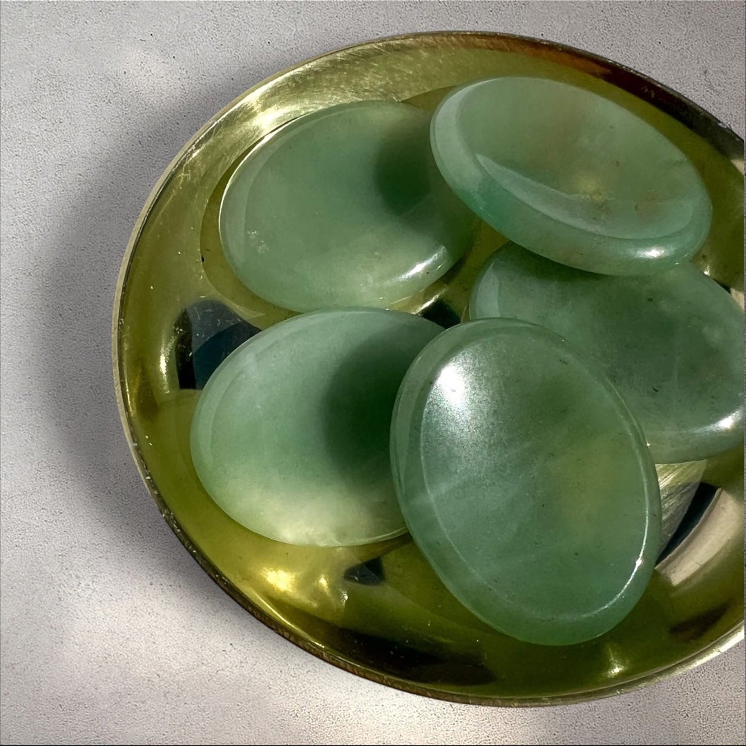 Rock + Realm Crystals green aventurine worry stones, smooth polished oval shape with thumb dip for anxiety relief in a brass dish