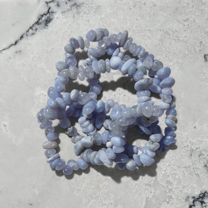 Stack of Blue Agate crystal chip gemstone bracelets on a marble surface