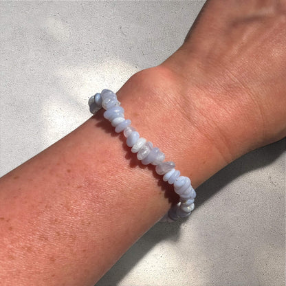 Blue Agate crystal chip gemstone bracelet on a wrist against a neutral background