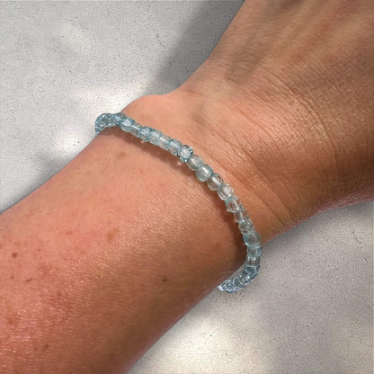 Blue Topaz beaded bracelet on a wrist against a neutral background