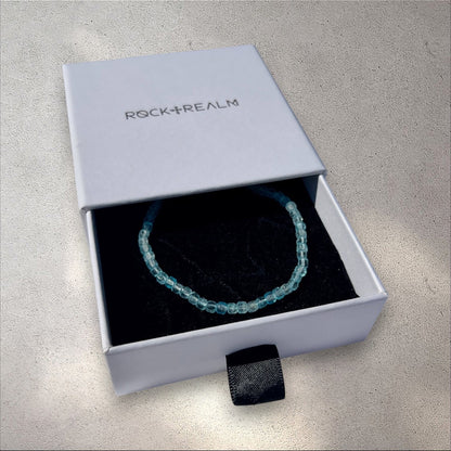 Blue Topaz crystal cube beaded bracelet in a 'Rock+Realm' box on a white fabric background