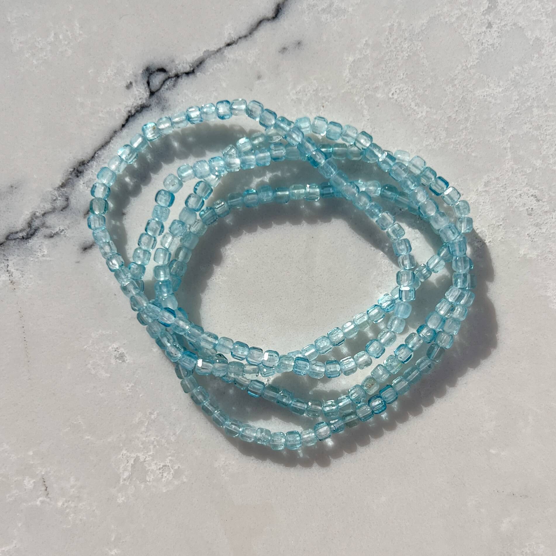 Blue Topaz gemstone beaded bracelet on a marble surface