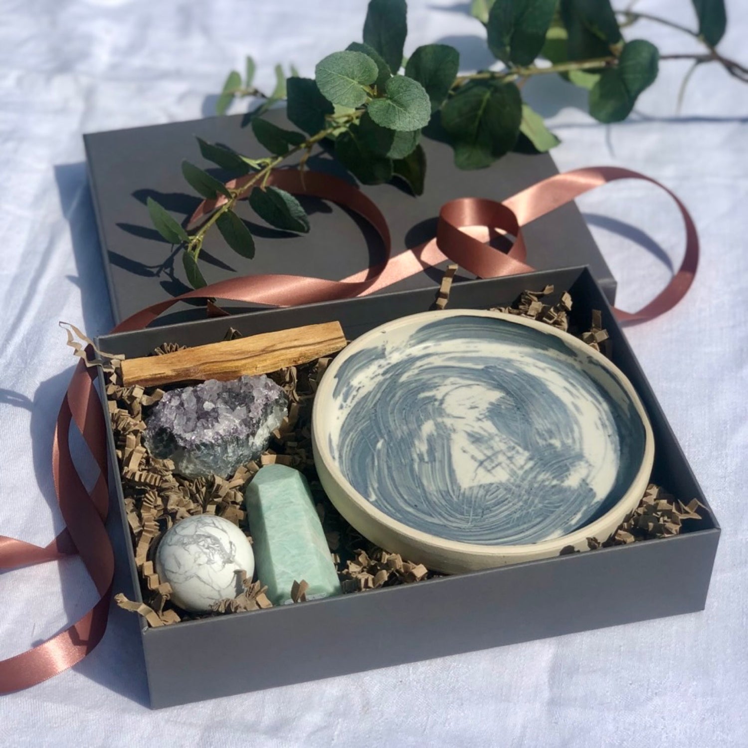 Grey luxury gift box with handcrafted ceramics and healing crystals
