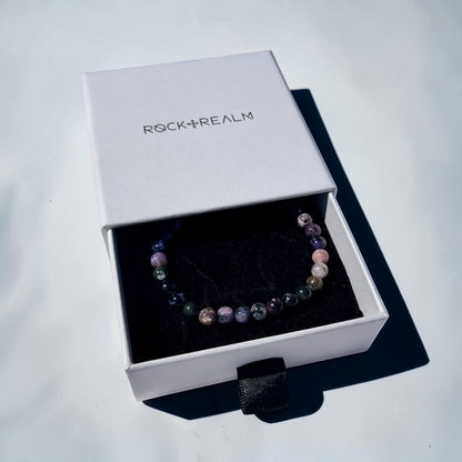 Black, Purple, grey & pink Chaorite crystal bead Bracelet in a 'Rock + Realm' box on a white background