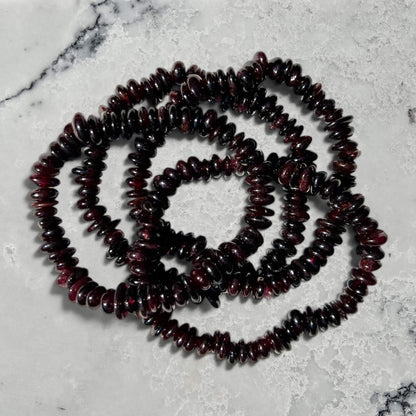 Stack of Garnet beaded bracelets on a marble surface