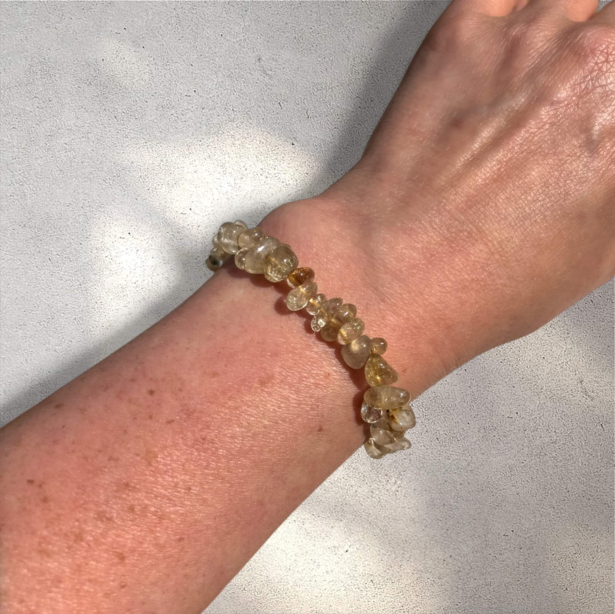 Yellow and clear golden rutilated quartz crystal chip bracelet on a woman's wrist