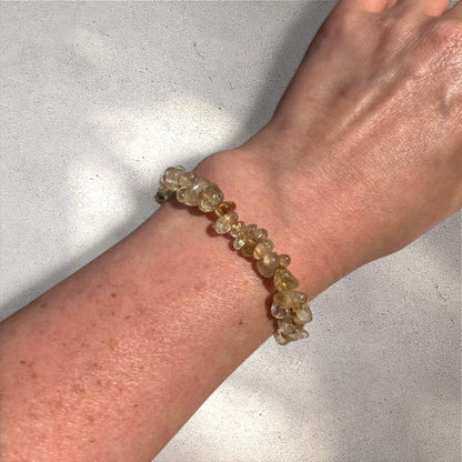 Yellow and clear golden rutilated quartz crystal chip bracelet on a woman's wrist