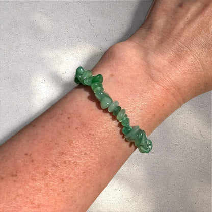 Green Aventurine crystal chip bracelet on a woman's wrist against a neutral sunlit background
