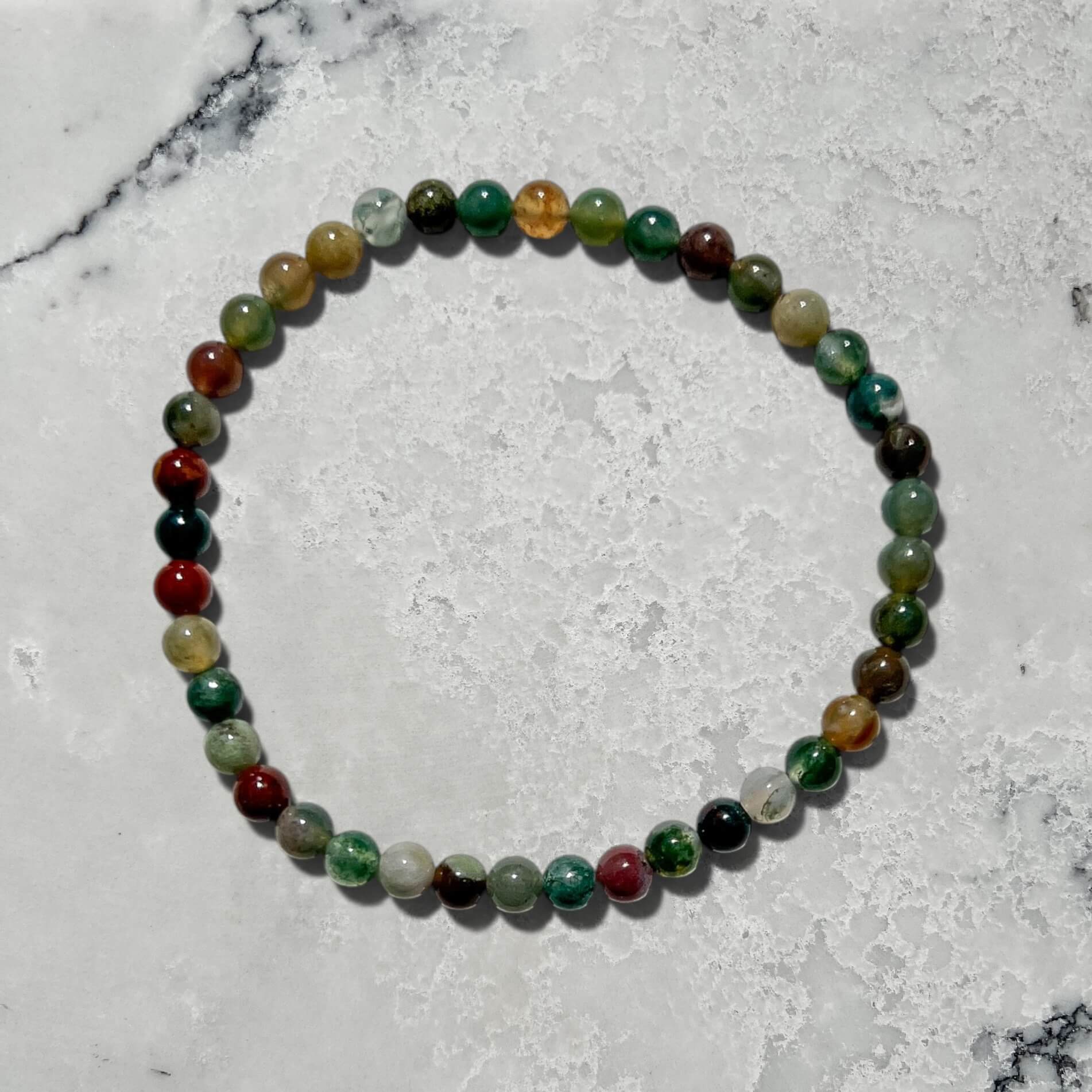 Green jasper crystal bead bracelet on a marble surface