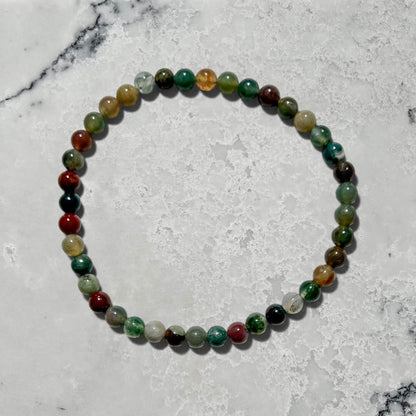 Green jasper crystal bead bracelet on a marble surface