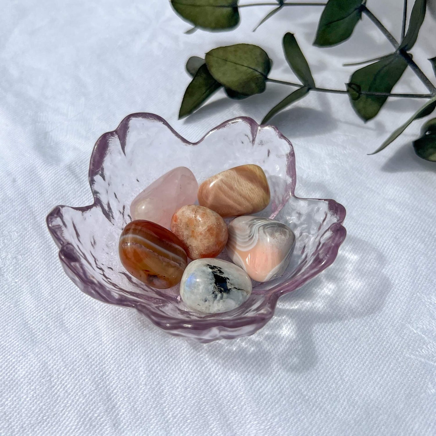 A small trinket dish filled with feminine pink coloured crystal tumblestones sold in the UK