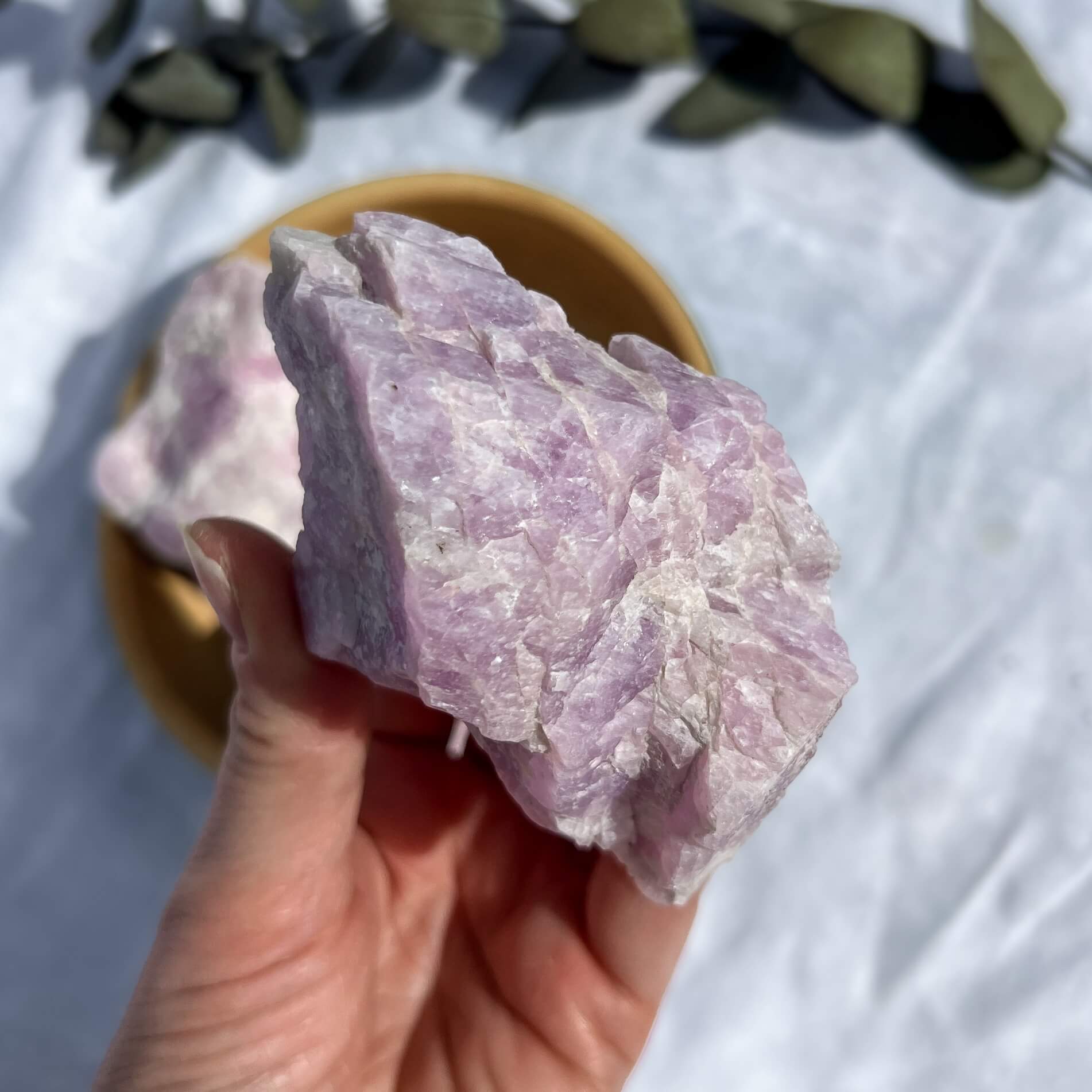 extra large lilac coloured raw kunzite crystal piece held to camera
