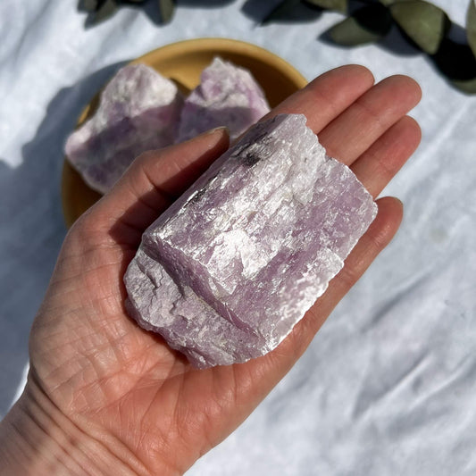 extra large lilac coloured raw kunzite crystal piece shimmering on an open hand