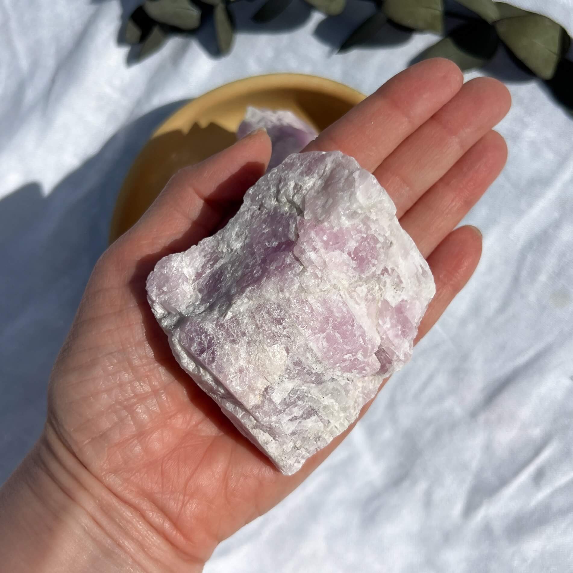 Chalky extra large lilac coloured raw kunzite crystal piece in an outstretched hand