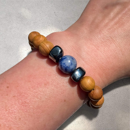Sodalite and cedar wood bead Bracelet on a wrist against a neutral background
