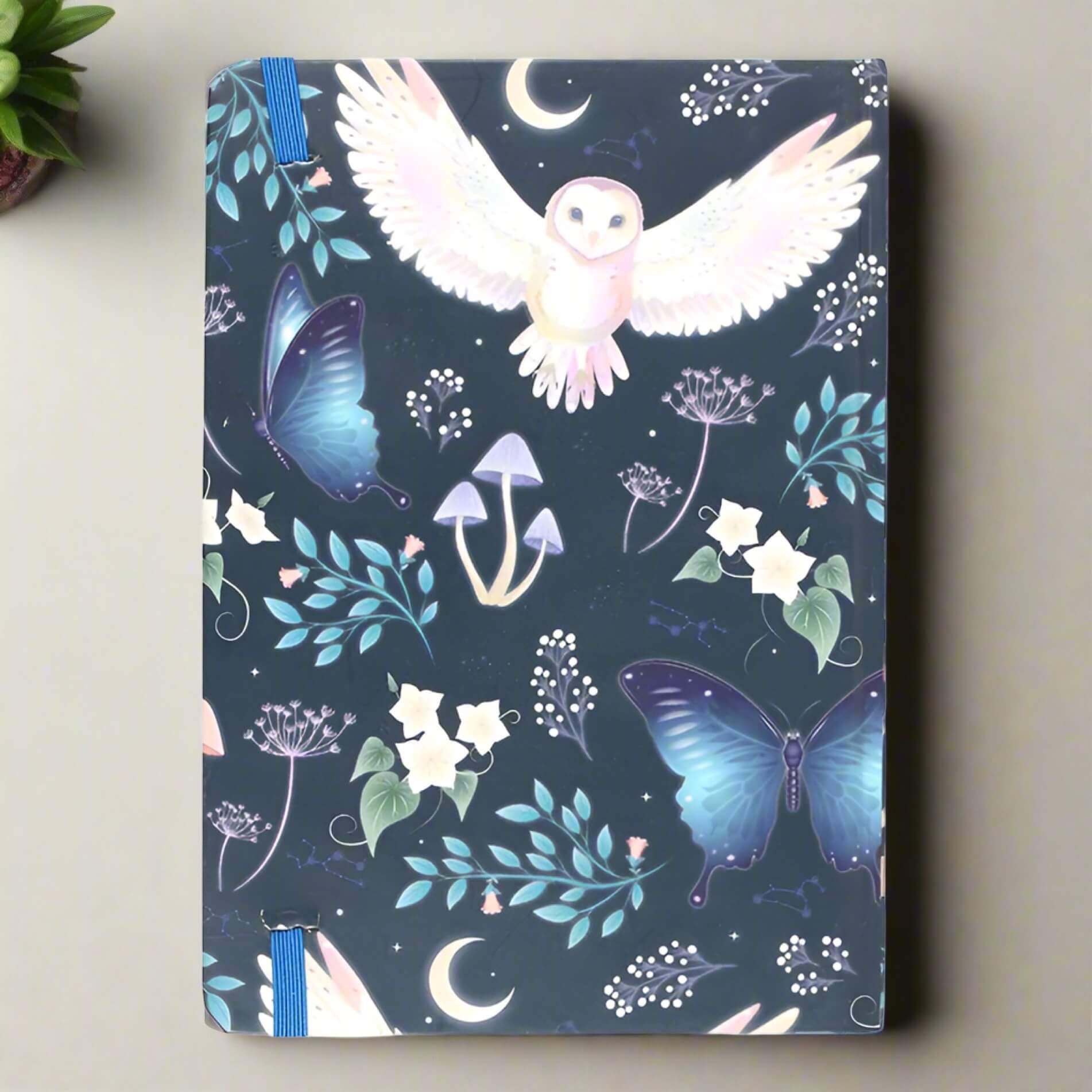 Rock + Realm Crystals blue mystical owl journal with butterflies, mushrooms, moons, and constellations.