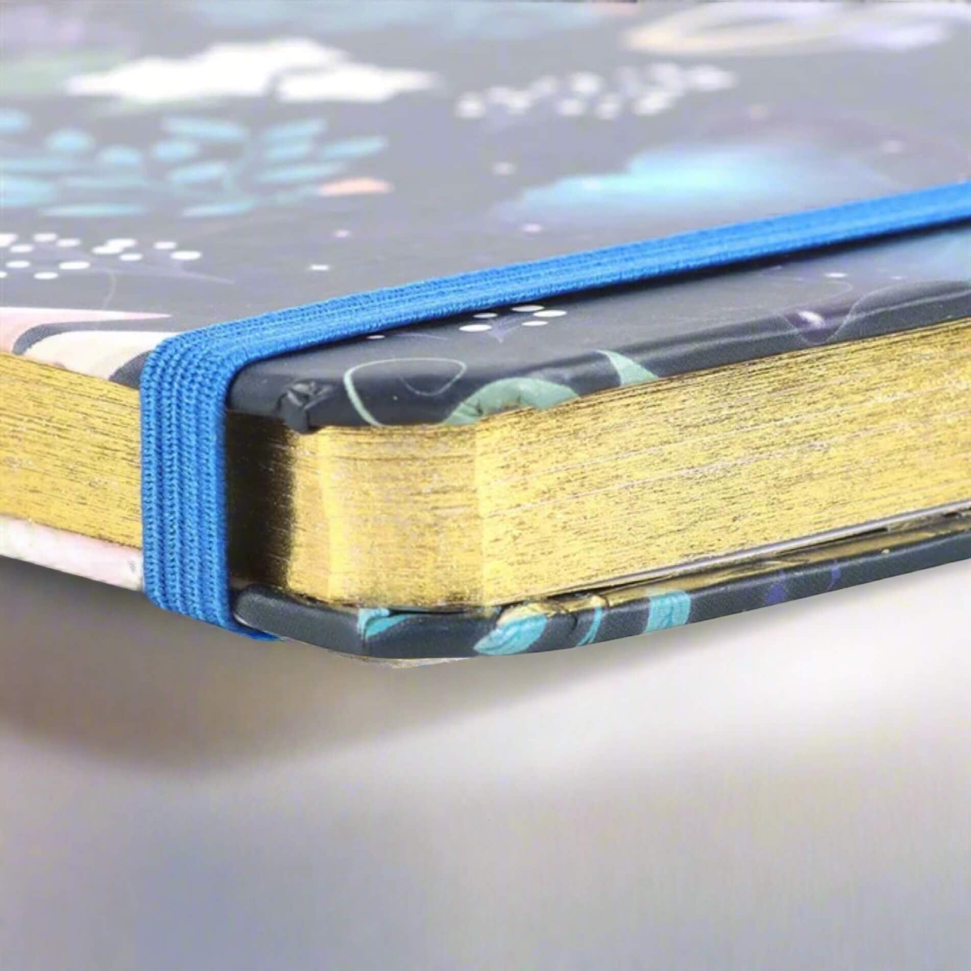 Rock + Realm Crystals blue mystical owl journal notebook with gold gilded edges and blue elastic closure.