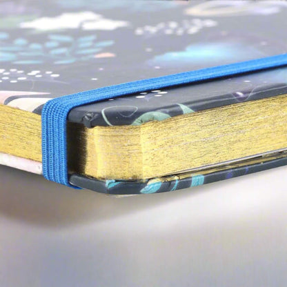Rock + Realm Crystals blue mystical owl journal notebook with gold gilded edges and blue elastic closure.