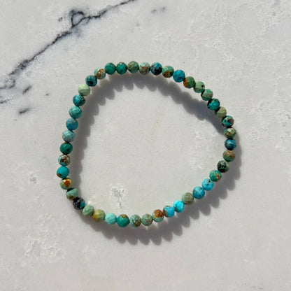 Natural Turquoise crystal bead bracelet on a marble surface