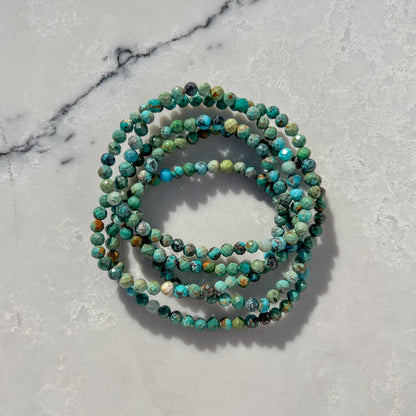 Natural Turquoise crystal bead bracelets on a light gray marble surface