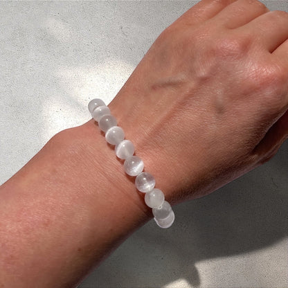 Rock + Realm Crystals large 8mm selenite beaded bracelet on a woman's wrist.