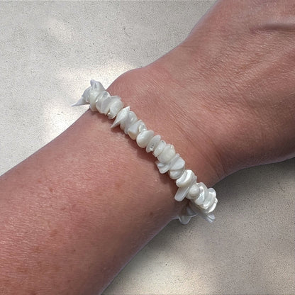 Rock + Realm Crystals white mother of pearl chip bracelet on a wrist. Natural, iridescent chips strung together.