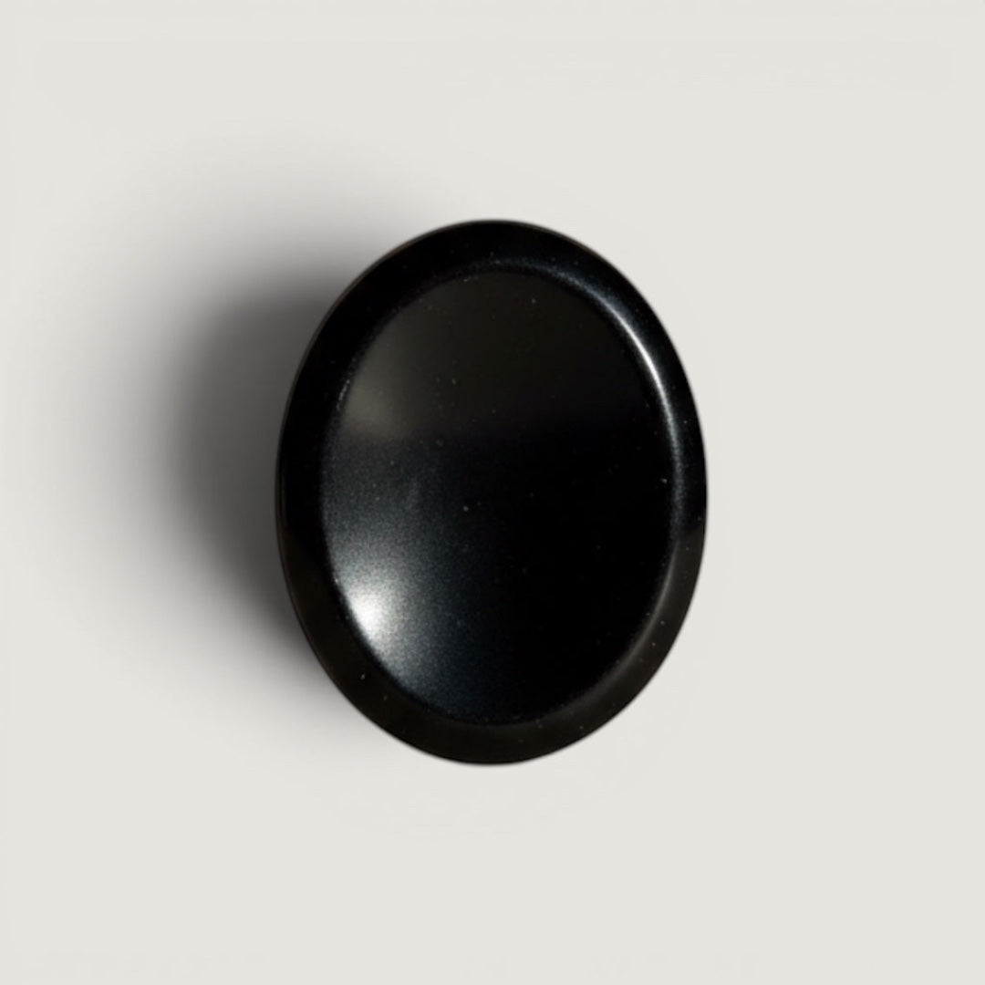 Rock + Realm Crystals black Obsidian worry stone with thumb indentation for grounding and stress relief.