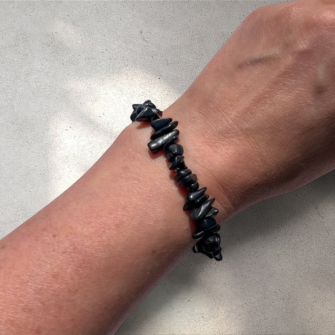 Rock + Realm Crystals black shungite chip bracelet on a woman's wrist, showcasing the natural, irregular shapes of the stones