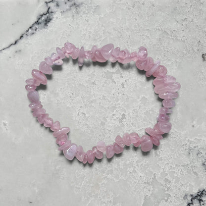 rose quartz crystal chip bracelet on a marble surface