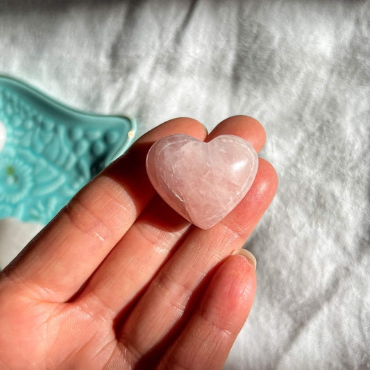 Pale pink rose quartz mini crystal heart on a hand