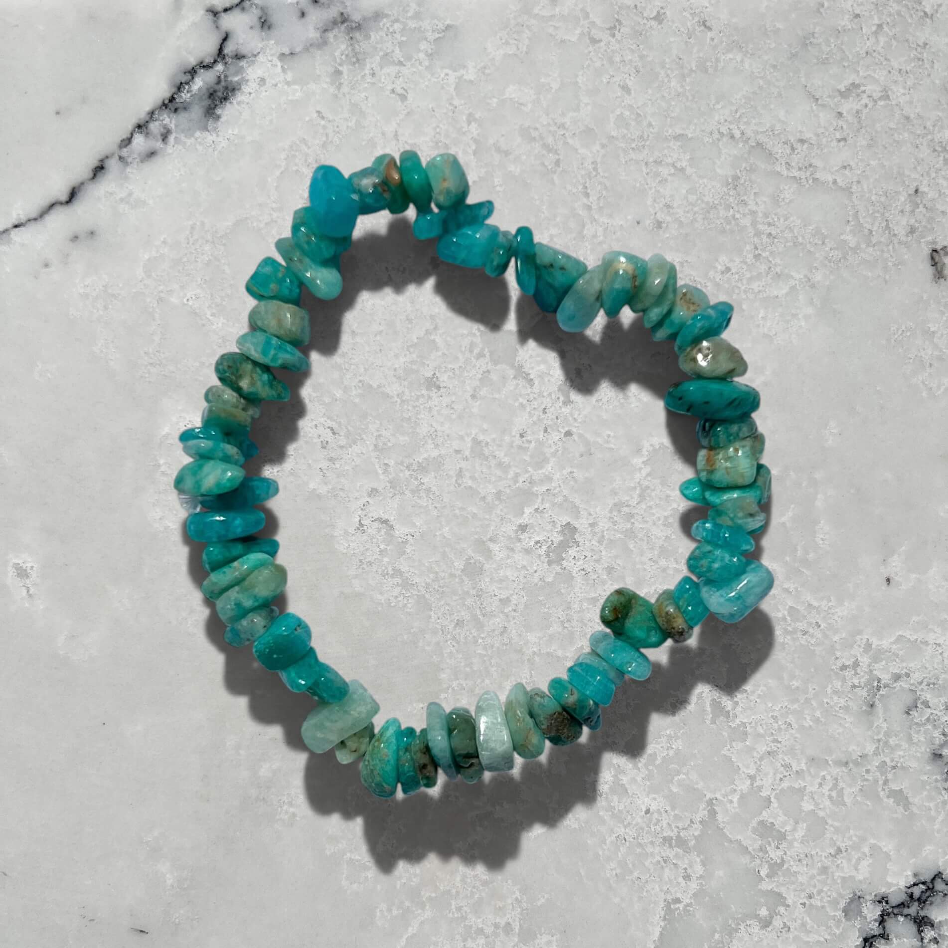 Turquoise coloured Russian amazonite crystal chip bracelet on a white marble surface