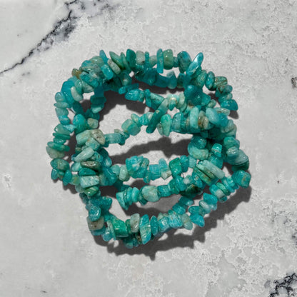 Turquoise coloured Russian amazonite crystal chip bracelets stacked on a marble surface